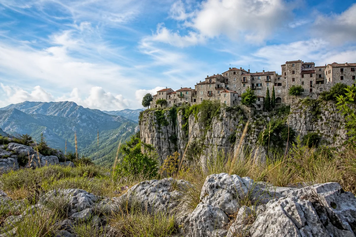 Maisons de pierre d’un village perché des Alpes-Maritimes accrochées au bord d’un plateau